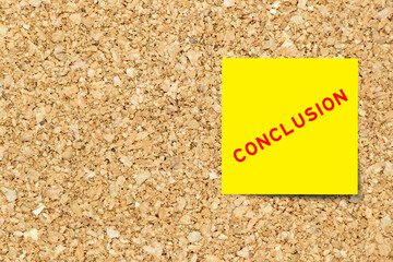 Yellow note paper with word conclusion on cork board background with copy space
