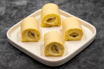 Banana roll cake. Roll cake with banana filling on a dark background. close up