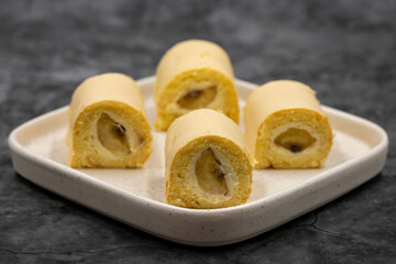 Banana roll cake. Roll cake with banana filling on a dark background. close up