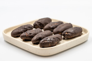 Special chocolate with dark outside and coconut inside. Dark chocolate with coconut filling on a white background. close up