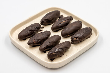 Special chocolate with dark outside and coconut inside. Dark chocolate with coconut filling on a white background. close up