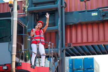 Obraz premium Black female dock worker control loading containers box from cargo at warehouse container yard. Marine and carrier insurance concept. logistic shipping yard