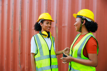Two friends Black female dock worker relax talking in break time at warehouse container yard. Marine and carrier insurance concept. logistic shipping yard
