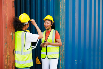 Two friends Black female dock worker relax talking in break time at warehouse container yard. Marine and carrier insurance concept. logistic shipping yard