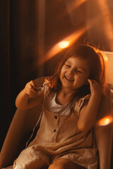 Cute toddler little girl having fun alone at home. Image shooted with soft focus in warm light.