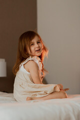 Fototapeta premium Cute toddler little girl having fun alone at home. Image shooted with soft focus in warm light.