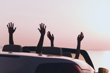 Photo of carefree excited boyfriend girlfriend rising arms going honeymoon driving cabriolet...