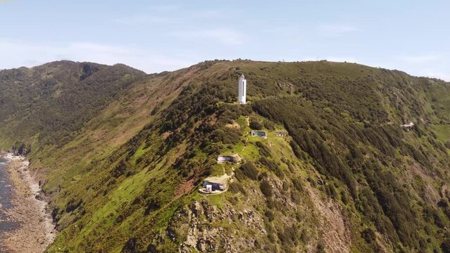 aerial footage of a lighthouse in a cliff next to the sea in Gorliz, Basque country, Spain