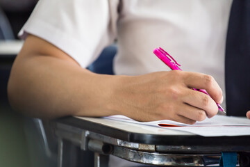 high school,university student study.hands holding pencil writing paper answer sheet.sitting lecture chair taking final exam attending in examination classroom.concept scholarship for education abroad