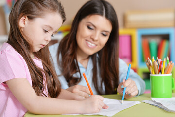 little girl in pink shirt drawing