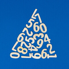 the shape of the triangle formed with wooden numbers on a blue background	