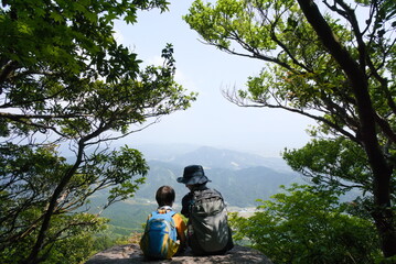 山頂で休憩する親子