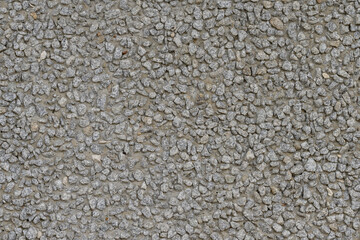 The texture of a gray concrete wall with gravel.