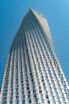 Dubai, UAE - 11.03.2017: Low angle wide vertical shot of Cayan Tower, or Infinity Tower, famous skyscraper in Dubai Marina area. Blue sky in the back.
