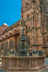 Nice view of the Virtue Fountain (Tugendbrunnen) in front of the church St. Lorenz in Nürnberg, Germany. The Late Renaissance fountain made of bronze presents personifications of the seven virtues.