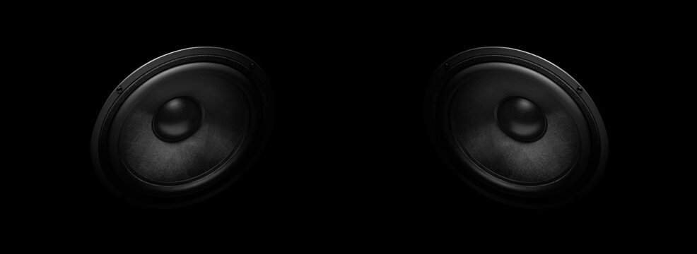 A pair of modern powerful sound speakers on a dark background.