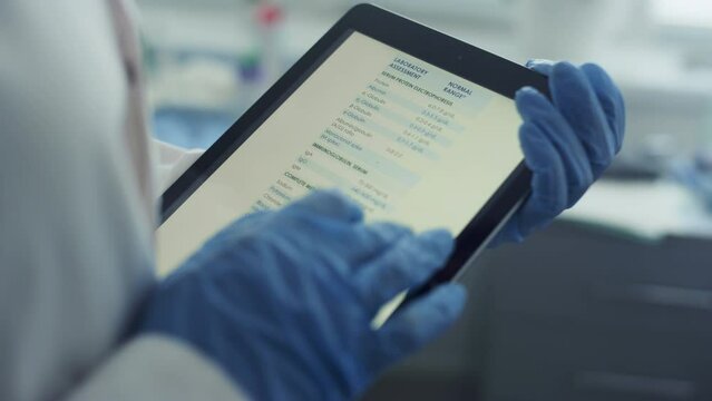 Doctor hands using tablet checking health history data in tablet in office.