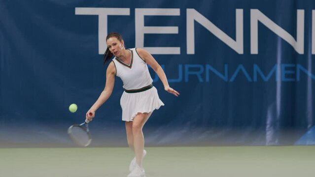 Female Tennis Player Hitting Ball with a Racquet During Championship Match. Professional Woman Athlete Receives and Lands Perfect Backhand Shot. World Sports Tournament. Slow Motion Full Shot Playback