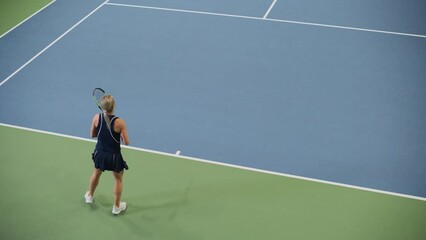 Female Tennis Player Servers by Hitting Ball with a Racquet During Championship Match. Professional...