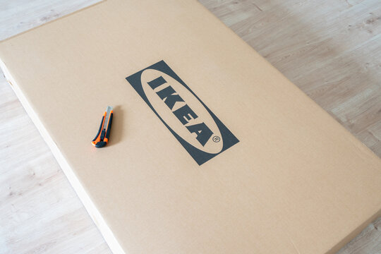 Celadna, Czechia - 05.07.2022: Detail shot of a Top of cardboard box with Ikea logo on it and pen knife. Ikea company. Do it yourself concept. Assembling furniture. Moving to new home.