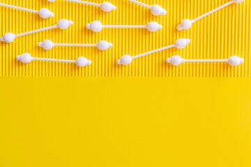 top view of hygienic cotton swabs on textured and yellow background with copy space.