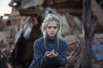 young girl screams against the background of a destroyed house. looks at the camera. military...