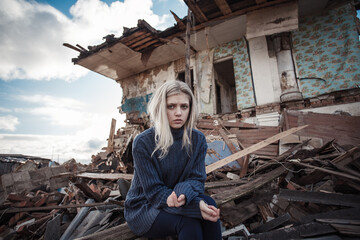 young girl screams against the background of a destroyed house. looks at the camera. military...