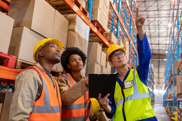 Asian mature foreman pointing upwards and african american young male and female workers looking up