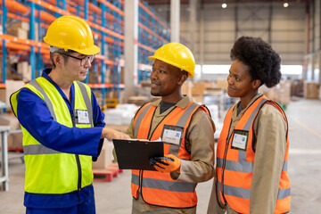 Asian mature foreman explaining over clipboard to african american young male and female workers