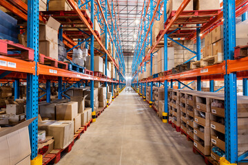 Diminishing perspective of flooring amidst shelves with cardboard boxes in storage compartment