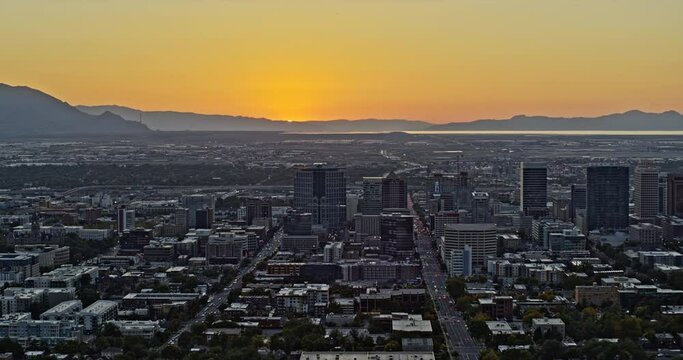 Salt Lake City Utah Aerial v31 slow pan shot of the west with beautiful orange sun setting in the background and downtown cityscape in the foreground - Shot with Inspire 2, X7 camera - October 2021