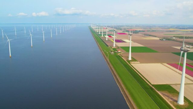 Aerial view of wind turbines in Windpark Noordoostpolder in Urk, Netherlands. Working offshore wind farm, sunset view. Concept: power plant, climate change, sustainable resources, global warming, alte
