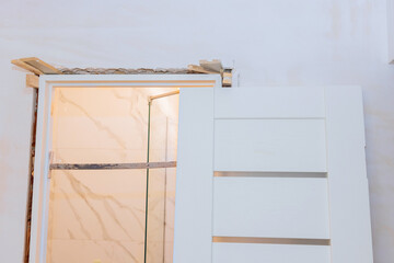Home under reconstruction with installing door unit the door frame using a mounting foam