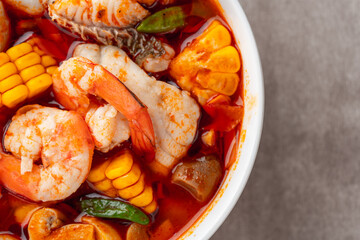 Shrimp soup bowl, Tom yum or tom yam is a type of hot and sour Thai soup, usually cooked with shrimp (prawn). Tom yum has its origin in Thailand.