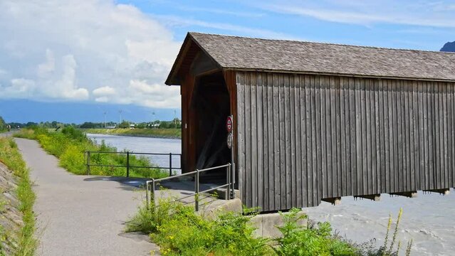Entrance and interior of the old bridge over the Rhine in Vaduz (Alte Rheinbrucke). Wooden roofed bridge over the river Rhine on the border between Vaduz in Liechtenstein and Sevelen in Switzerland. 