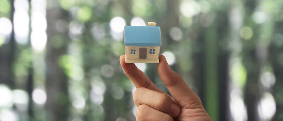 Hand holding  house model. property insurance and security Buy rent house concept