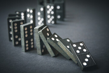 Black dominoes chain on dark table background