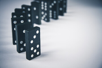 Black dominoes chain on white table background