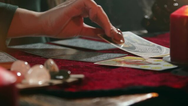 The fortune teller lays out and turns over Tarot cards in the process of divination.