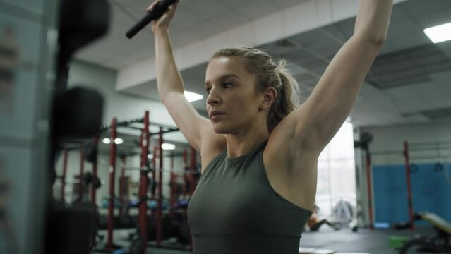 Young caucasian woman  exercising with weights  on a gym. Shot with RED helium camera in 8K. 