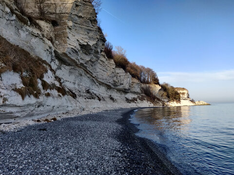 Beautiful of a rocky cliff on sunny sea water against a light sky in Stevns Klint Store Denmark