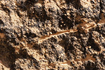 Texture of sandstone stone with scratches and cracks. Closeup