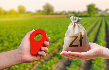 Hands with location pin and polish zloty money bag. Estimation cost of plots. Agriculture...