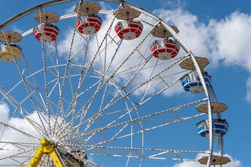 Closeup of a Ferris wheel in the amusement park against a cloudy sky