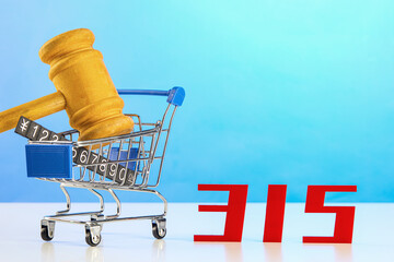 Closeup of a shopping cart with a hammer and a price tag next to 315- world consumer rights day - obrazy, fototapety, plakaty