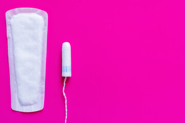 top view of white panty liner and tampon on purple background.
