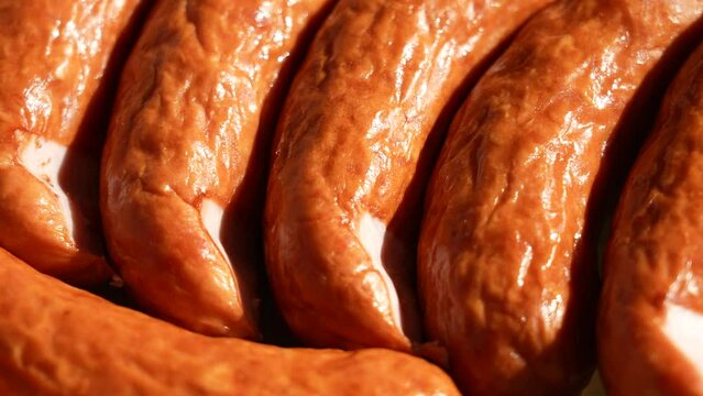 Close-up view 4k stock video footage of organic smoked sausages isolated on green plate background