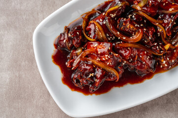 ayam goreng mentega or fried chicken with soy sauce, butter and onion served on white plate.