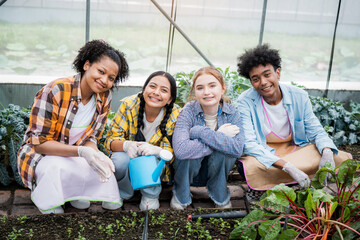 Portrait of teenage girl and boy playing in the vegetable garden.