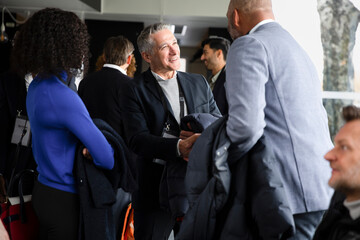 Businessmen greeting each other during seminar at conference center